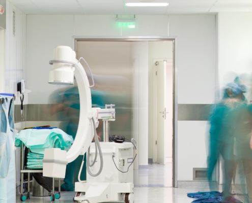 Nurses walking in hallway with mobile x-ray machine